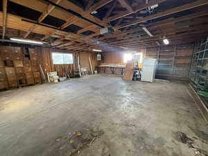 Garage with a garage door opener and white refrigerator