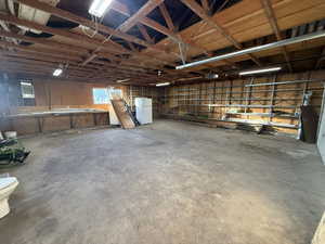 Garage featuring white refrigerator and a garage door opener