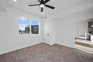 Carpeted spare room with ceiling fan