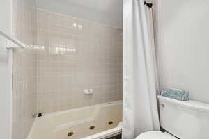 Bathroom featuring toilet and shower / tub combo