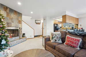 Carpeted living room with a tiled fireplace