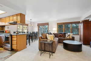 Living room featuring light carpet and a notable chandelier