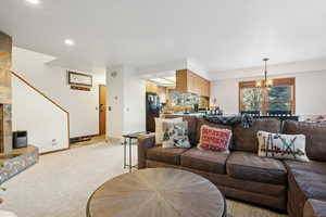 Living room with an inviting chandelier and light colored carpet