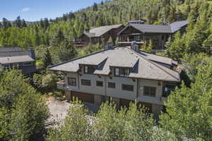 Aerial view of property and surrounding area featuring a heavily wooded area and a mountainous background