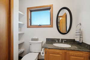 Bathroom featuring vanity, built in shelves, and toilet