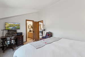 Bedroom with light carpet and lofted ceiling