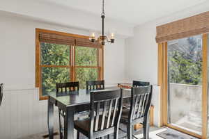 Dining space featuring a chandelier and wainscoting