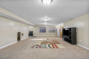 Interior space with light carpet and a textured ceiling