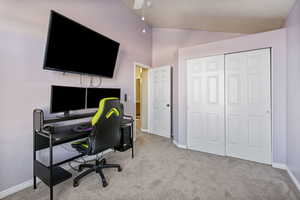 Carpeted home office with high vaulted ceiling