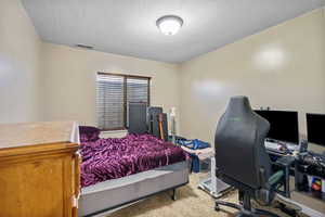 Bedroom featuring a textured ceiling and carpet flooring