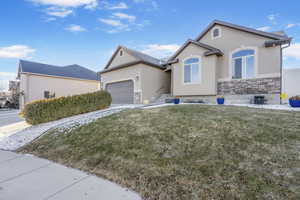 View of front facade featuring a garage and a front yard