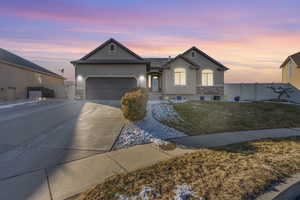 Ranch-style house featuring a garage and a lawn