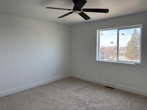 Carpeted empty room featuring ceiling fan