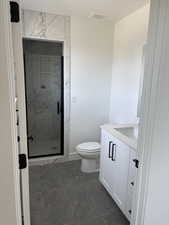 Bathroom featuring vanity, an enclosed shower, and toilet