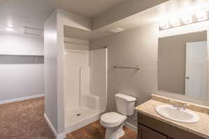 Bathroom with toilet, walk in shower, and vanity