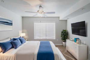 Carpeted bedroom featuring ceiling fan