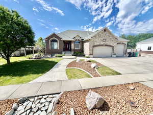 French country inspired facade with a garage and a front yard