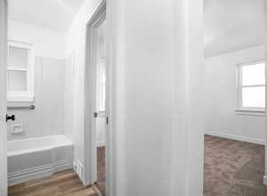 Bathroom featuring wood-type flooring and shower / washtub combination