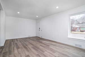 Empty room featuring light hardwood / wood-style floors and plenty of natural light