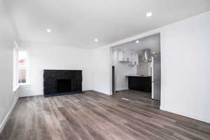 Unfurnished living room with a high end fireplace and hardwood / wood-style flooring