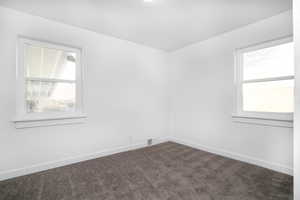 Spare room with dark colored carpet