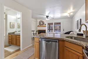 Kitchen featuring sink, a textured ceiling, light hardwood / wood-style floors, and dishwasher