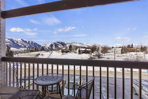 Snow covered back of property with a mountain view