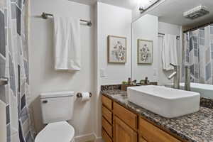 Bathroom with vanity, a textured ceiling, and toilet