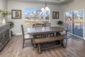 Dining area with a mountain view, a notable chandelier, and hardwood / wood-style floors