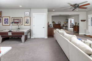 Living room featuring carpet and ceiling fan