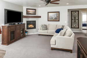 Living room with ceiling fan and light carpet