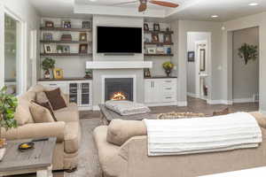 Living room with ceiling fan and hardwood / wood-style floors