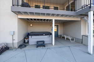 View of patio / terrace with a hot tub and a balcony