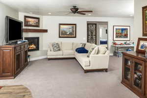 Living room featuring light carpet and ceiling fan