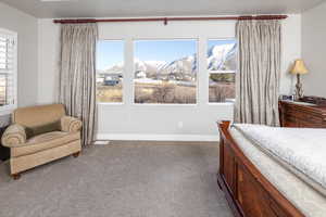 Carpeted bedroom with multiple windows and a mountain view