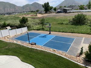 View of basketball court featuring a mountain view, a lawn, and tennis court