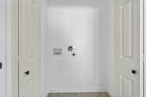 Washroom featuring electric dryer hookup, washer hookup, and light wood-type flooring