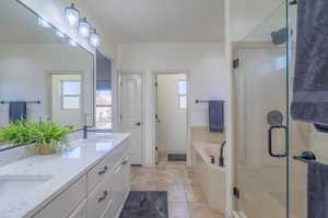 Bathroom with tile patterned flooring, plus walk in shower, and vanity