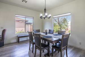 Dining space with hardwood / wood-style floors and a chandelier