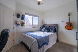 Carpeted bedroom featuring ceiling fan