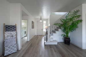 Foyer entrance with wood-type flooring and washer / clothes dryer