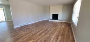 Living room featuring a brick fireplace and a healthy amount of sunlight!