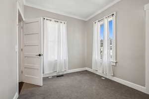 Carpeted empty room with ornamental molding