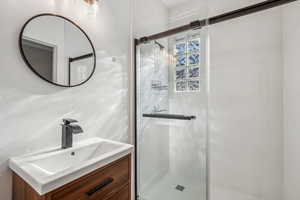 Bathroom with vanity and a shower with door