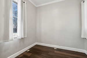 Spare room featuring wood-type flooring and ornamental molding