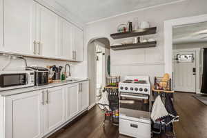 Kitchen featuring white appliances, sink, a textured ceiling, and white cabinets