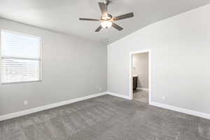 Unfurnished room featuring vaulted ceiling, light carpet, and ceiling fan