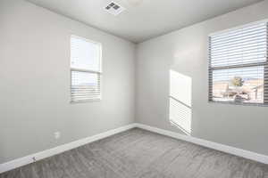 Carpeted spare room featuring a healthy amount of sunlight