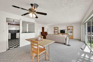 Carpeted living room featuring a textured ceiling and ceiling fan