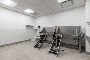 Miscellaneous room with tile walls and a paneled ceiling